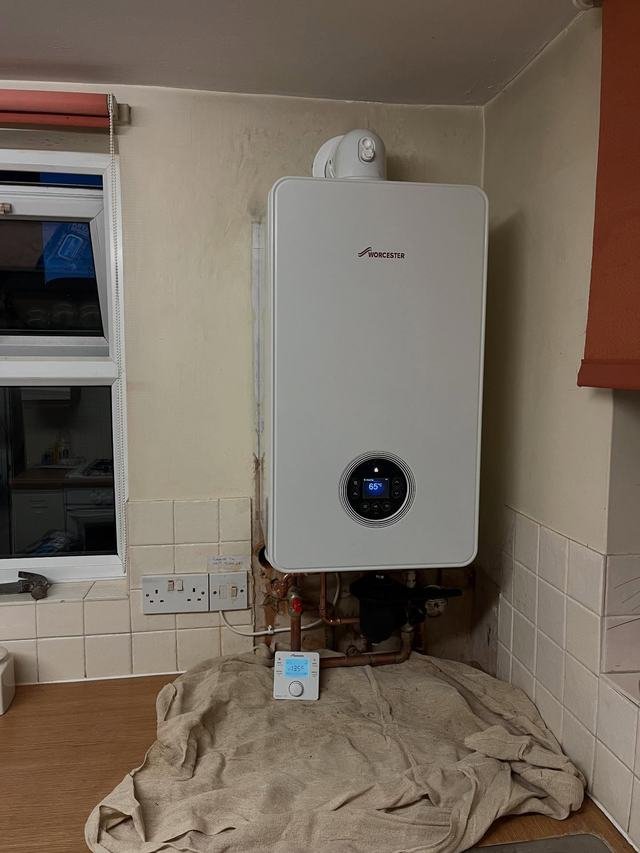 Combination boiler installed on a kitchen wall with a dust sheet below