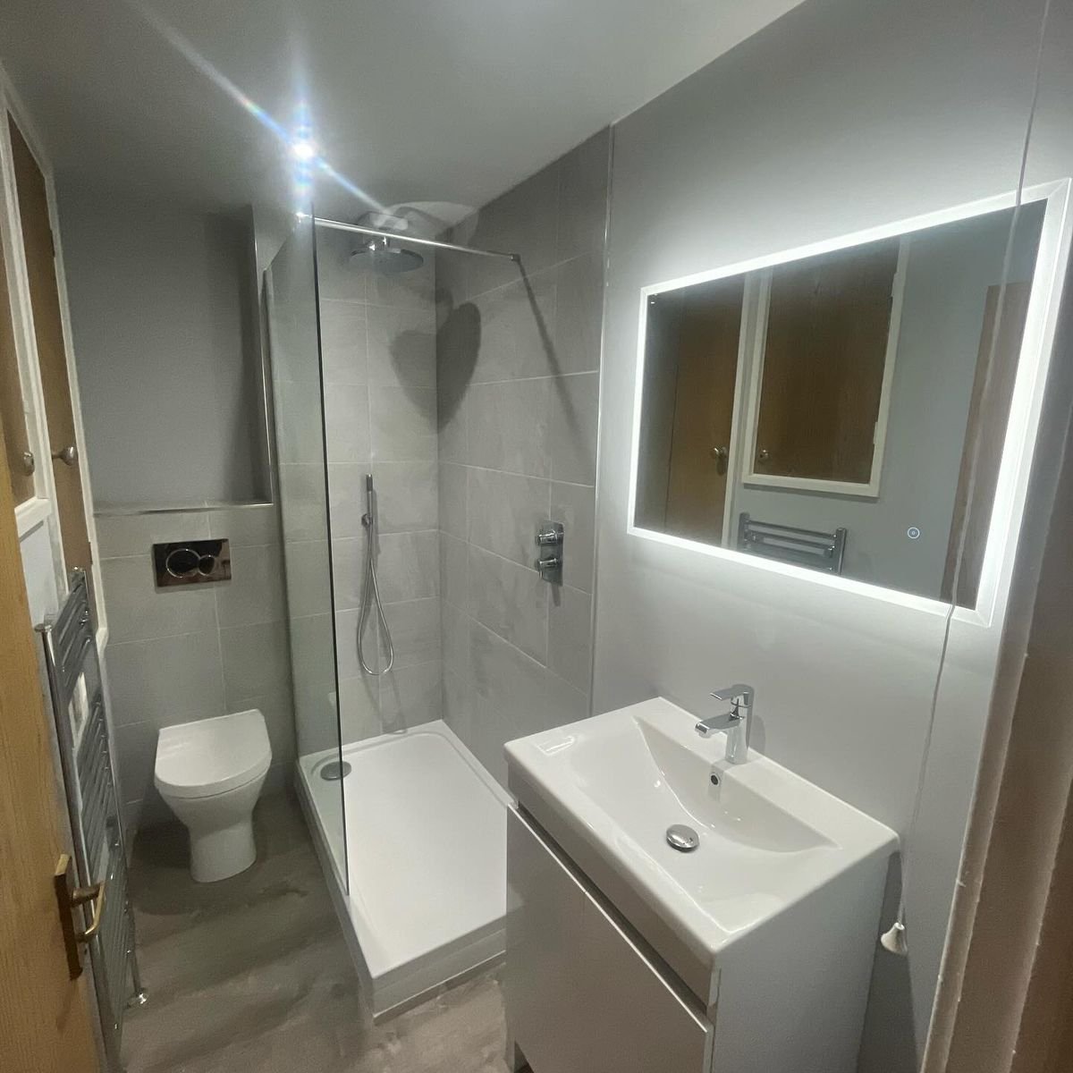 Didcot bathroom after: walk-in shower, vanity basin and a backlit mirror
